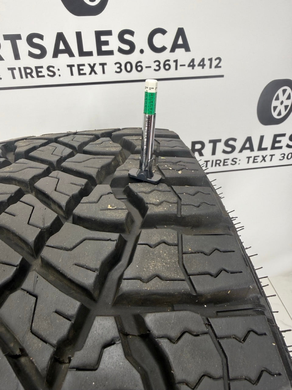 Tread depth gauge on LT305/70R18 Goodyear Wrangler Territory MT takeoff tire — 15/32 inch